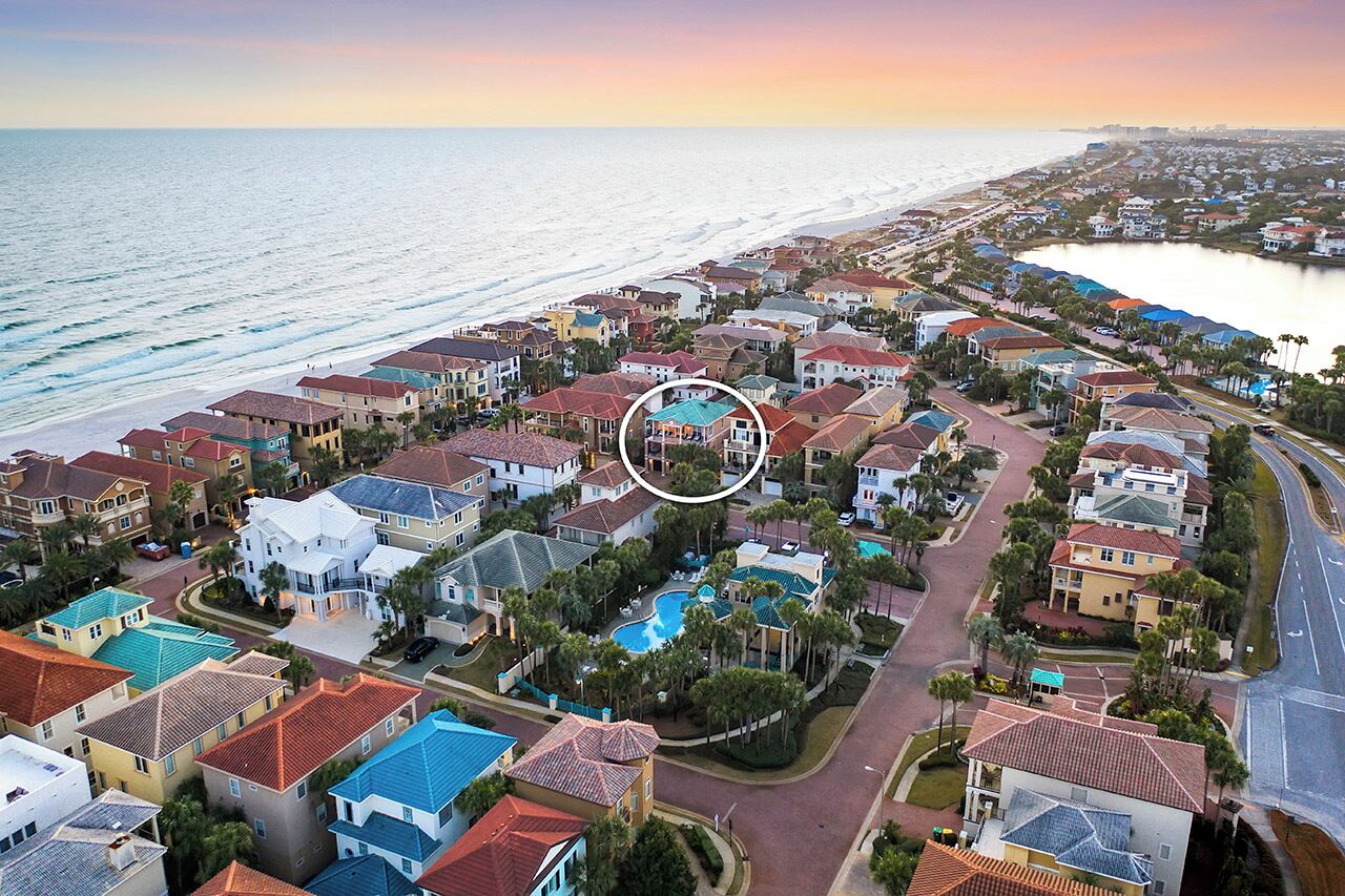 A coastal residential area with houses, a swimming pool, and a view of the ocean.