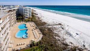 A resort with a beach, a pier, and a pool area.