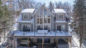 A large, two-story house with a covered porch and a fireplace. - Spacious Mountain Escape w/ Hot Tub and Fireplace (OAKLAND)