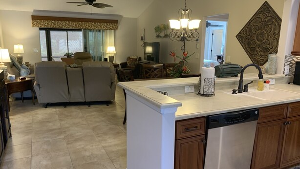 A spacious living area with a large sofa, a dining table, and a kitchen with a dishwasher. - Beautiful 3/2 Sm Dog Friendy home w/WiFi! Central Location to each town! (The Villages)