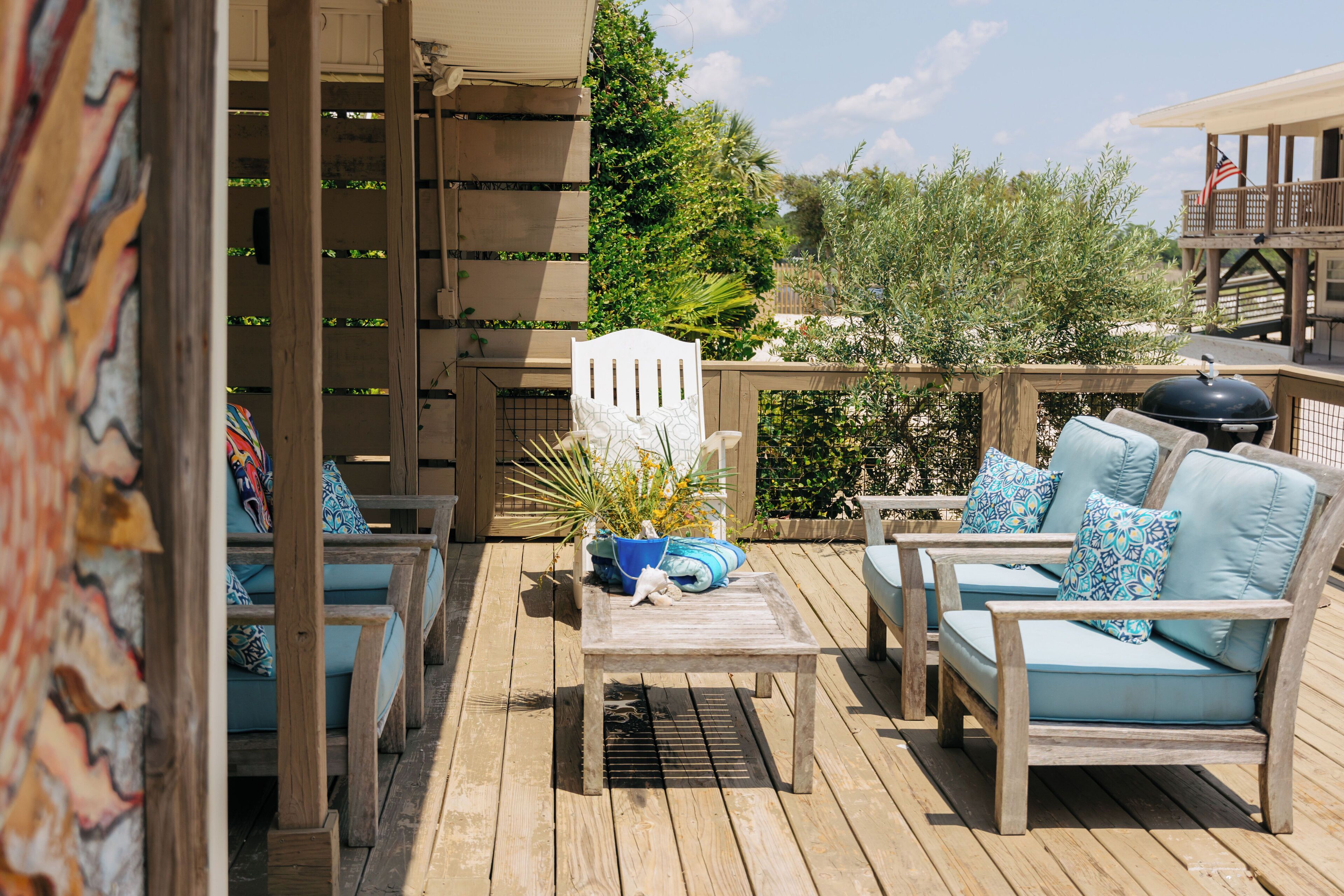 A wooden deck with outdoor furniture, including a sofa and chairs, and a table with decorative items.