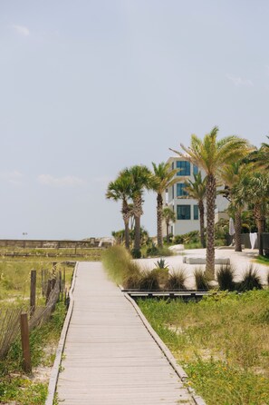 A wooden boardwalk leading to a modern building with palm trees. - SEAVIEW Grayton Beach 2 bd/2BA Gulf/Lake/VIEW/Closest 2 bedroom to beach! (Santa Rosa Beach)