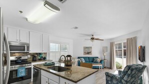 A modern kitchen with white cabinets, a granite countertop, and stainless steel appliances. - Gulfview II 101 | Ground Floor • 100 Steps to Beach • Free Beach Service • Sleep (Destin)