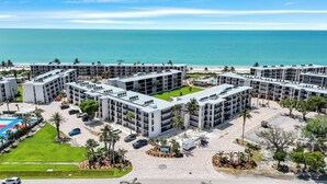 Et moderne hotelkompleks med flere bygninger, et poolområde og udsigt til stranden.