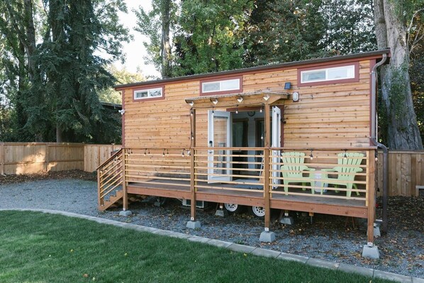 Eine Holzhütte mit Veranda, Treppe und kleiner Terrasse.
