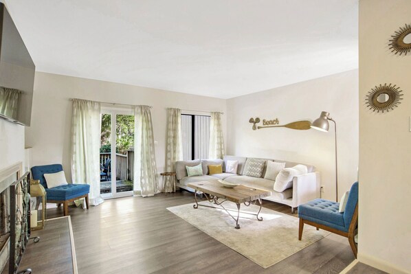 Ein geräumiges Wohnzimmer mit einer Sofagarnitur, einem Couchtisch und einer Stehlampe.