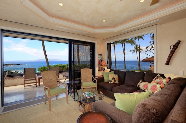 A spacious living area with a large glass door leading to a balcony overlooking the ocean. - Spectacular Corner Oceanfront Escape: Luxurious Makena Surf Resort G-206 (Makena, Maui)