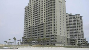 A tall, multi-story hotel with a uniform exterior and balconies. - Paradise Harbor Grand Panama PCB-Beachfront 2Bd+Bunks-2Ba-Pet Friendly (Panama City Beach)