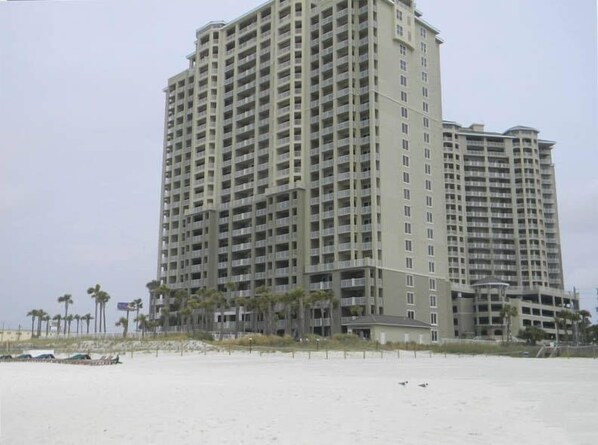 A tall, multi-story hotel with a uniform exterior and balconies.