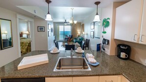 A modern kitchen with granite countertops, a stainless steel sink, and pendant lighting. - Paradise Harbor Grand Panama PCB-Beachfront 2Bd+Bunks-2Ba-Pet Friendly (Panama City Beach)