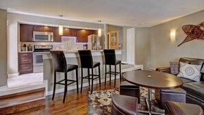 A modern kitchen with dark wooden cabinets, stainless steel appliances, and a bar area with bar stools. - Free SkyCard Activities - Remodeled, Close to Peak 8 - Peak 8 Village E35 (Breckenridge)