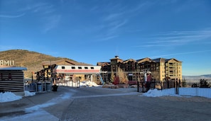A hotel with a red and white cabin, a ski lift, and a mountainous backdrop.