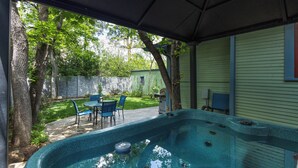 A backyard with a hot tub, patio chairs, and a covered area. - Beautiful Cheyenne Cañon Retreat with Hot Tub, Walk To Broadmoor Hotel & Trails. (Colorado Springs)
