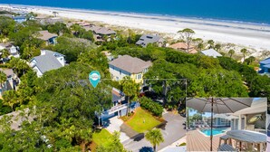 Zona residencial costera con casas, una playa y una piscina.