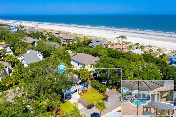 A coastal residential area with houses, a beach, and a pool.