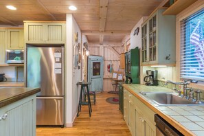 Enjoy cooking in this well-equipped kitchen with a central island, stainless steel appliances, and ample storage.