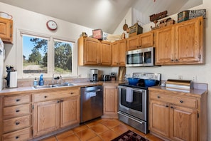 Enjoy cooking in this well-equipped kitchen with a large window offering a view of the surrounding landscape.