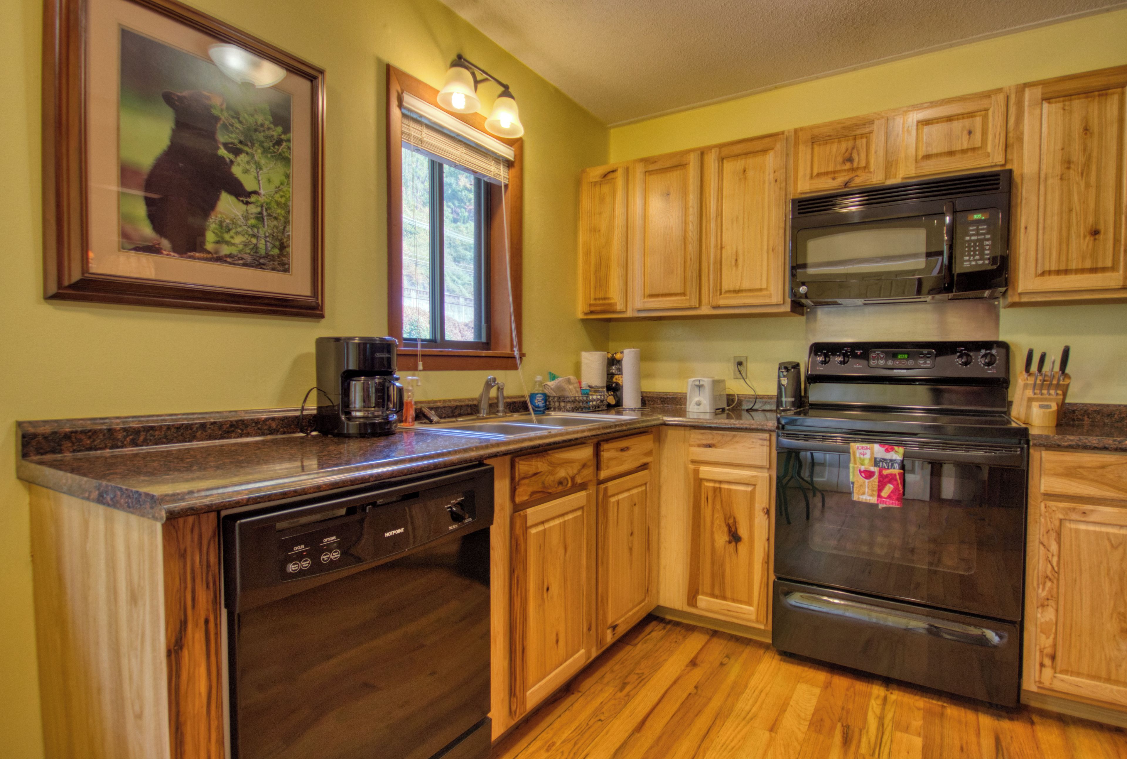 A kitchen with wooden cabinets, a stainless steel microwave, and a dishwasher.