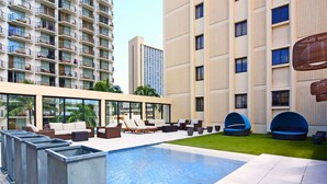 A rooftop pool area with lounge chairs and a small garden. - Spectacular Diamond Head and Ocean Views! Free Valet Parking, Wi-Fi, Pool! (Honolulu)