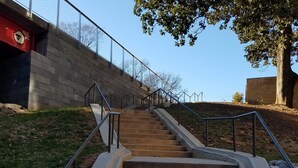 A set of concrete stairs with metal railings, leading up to a fenced area with a tree and a building in the background. - In heart of Atlanta, short walk to museums & restaurants FREE off street parking (Atlanta)