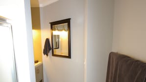A narrow hallway with a wooden floor, a towel hanging on the wall, and a mirror above a sink. - In heart of Atlanta, short walk to museums & restaurants FREE off street parking (Atlanta)