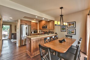 A spacious kitchen with wooden cabinets, a stainless steel refrigerator, and a large island with seating. - Luxury Condo, Private Hot Tub & Year-Round Recreation at Park City Racquet Club (Park City)
