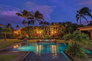 A rectangular swimming pool with a waterfall feature, surrounded by tropical vegetation and palm trees. - Expansive Mauna Lani Resort Estate with Pool, Garden, & Beach Access! (Waimea)