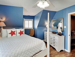 Une chambre à coucher avec un lit, une commode et un miroir.