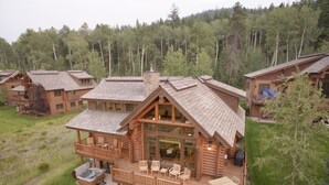 Une cabane en rondins dotée d’une grande terrasse, d’un espace salon extérieur et d’un jacuzzi.