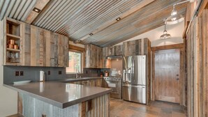 Una cocina con una isla central, electrodomésticos de acero inoxidable y armarios de madera.