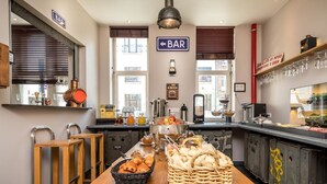 Una cocina con una mesa de madera, un letrero de bar y diversos electrodomésticos.