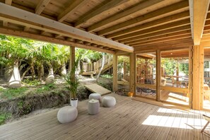 A wooden deck with potted plants and outdoor furniture.