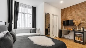 A modern hotel room with a bed, a seating area, a desk with a TV, and a kitchen counter. -  BİG URBAN STAY TAKSİM@WİTH SEA VİEW (Istanbul)