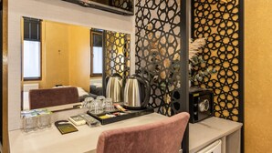 A hotel room with a desk, a mirror, a decorative screen, a safe, and a minibar. -  BİG URBAN STAY TAKSİM@WİTH SEA VİEW (Istanbul)