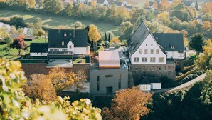 Un quartier résidentiel avec des maisons, un grand bâtiment doté d’un toit en pente et une route.