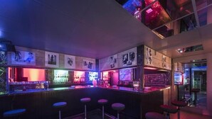 A bar area with stools, a counter, and various bottles. - L'usine (Belval)