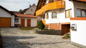 Ein Innenhof mit Kopfsteinpflaster, einer Holzbank und einem kleinen Baum.