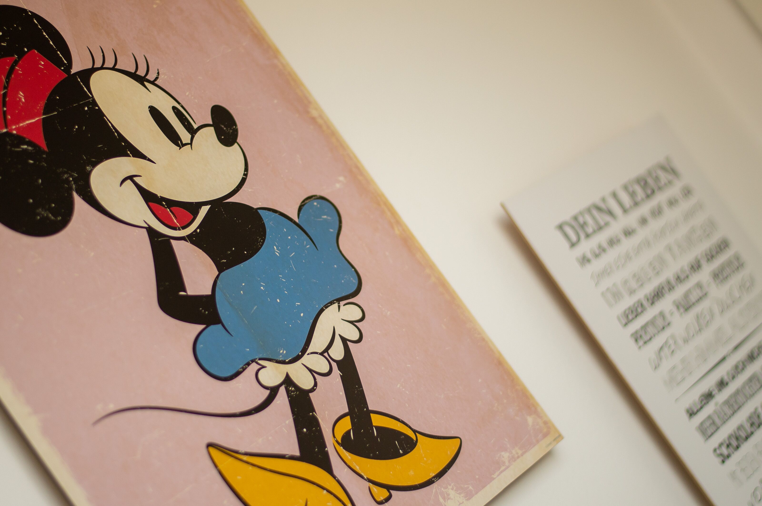 Ilustración de Mickey Mouse sobre un fondo rosa con un menú que detalla precios y servicios.