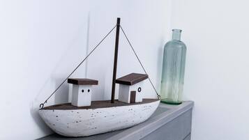 A model ship on a shelf next to a green bottle.