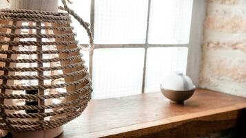 A wooden shelf with a woven rope lantern and a ceramic bowl.