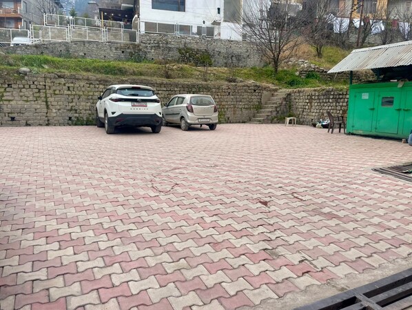 A paved parking area with two cars parked.