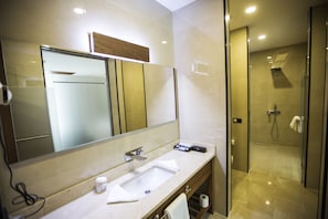 A modern bathroom with a large mirror, a sink, and a shower area. - Carissa Hotel (Mugla)