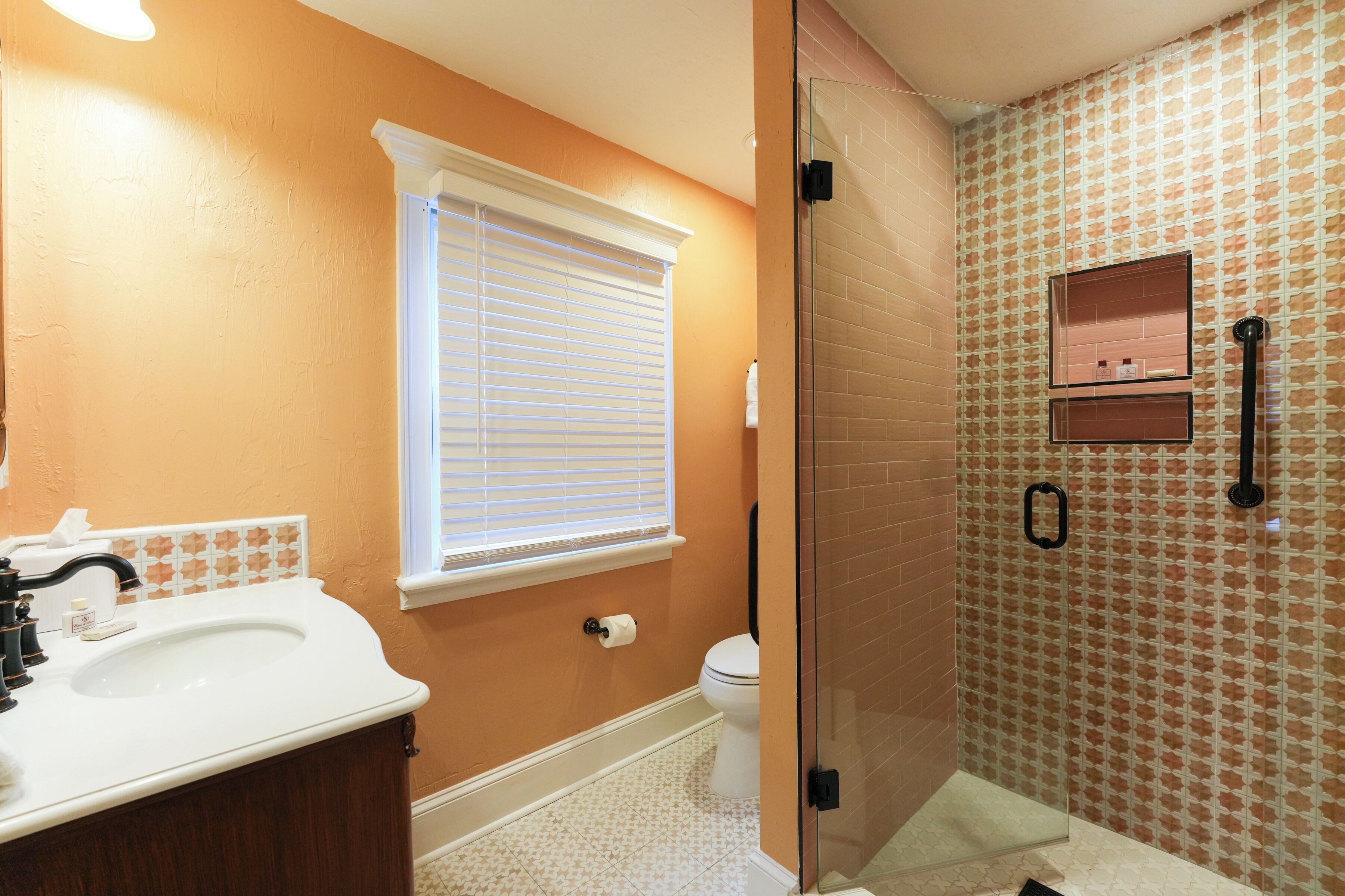 A bathroom with a white sink, a toilet, and a glass-enclosed shower area.