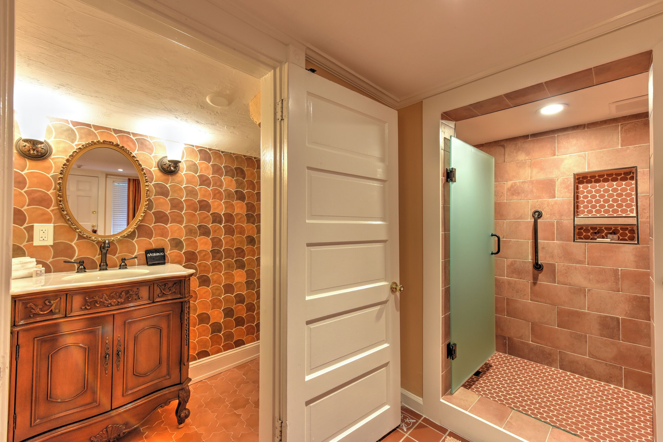 A bathroom with a stone-patterned wall, a white door, and a shower area with a tiled floor.