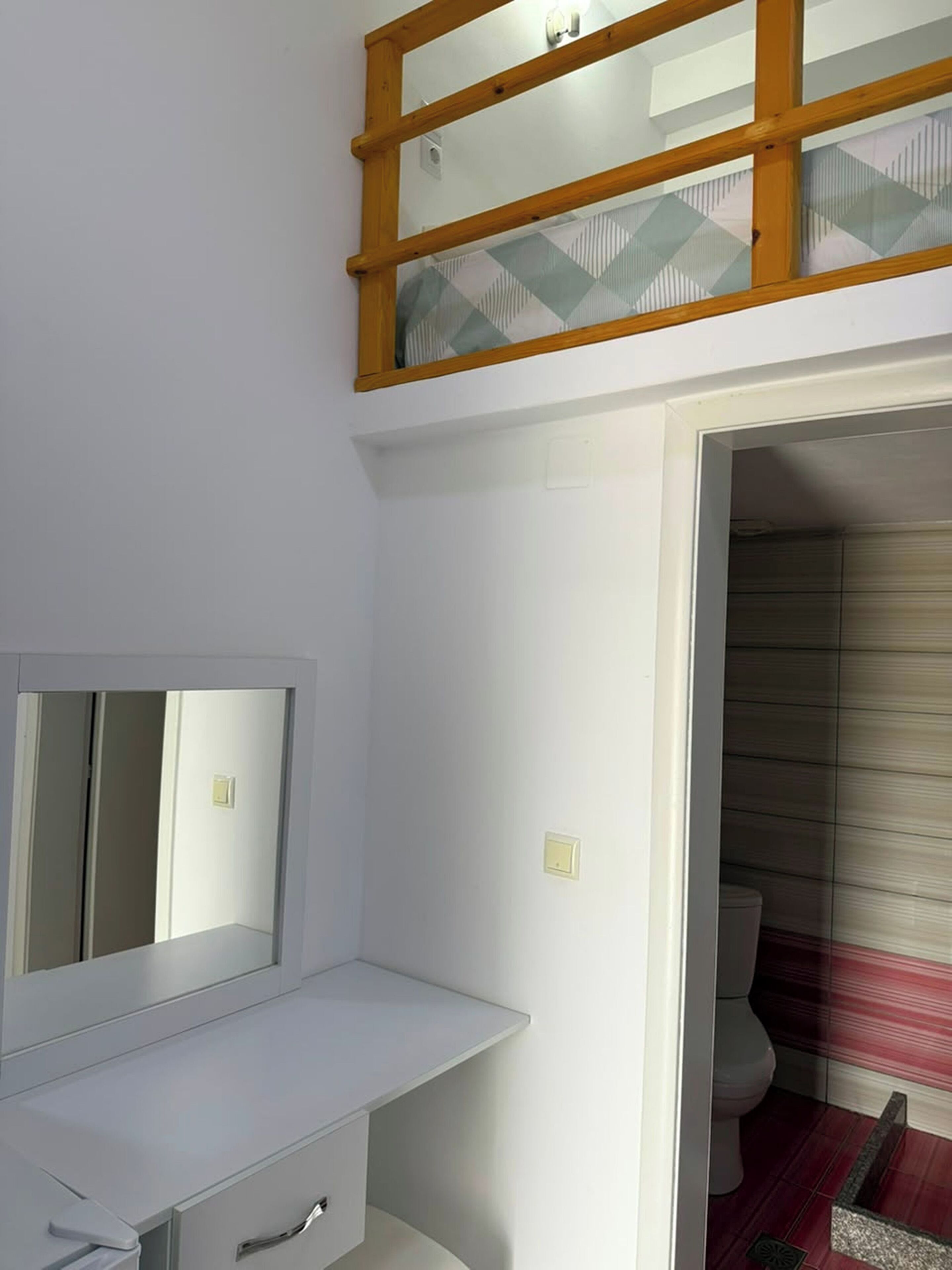 A bathroom with a white vanity, a mirror, and a shower area with a glass door.