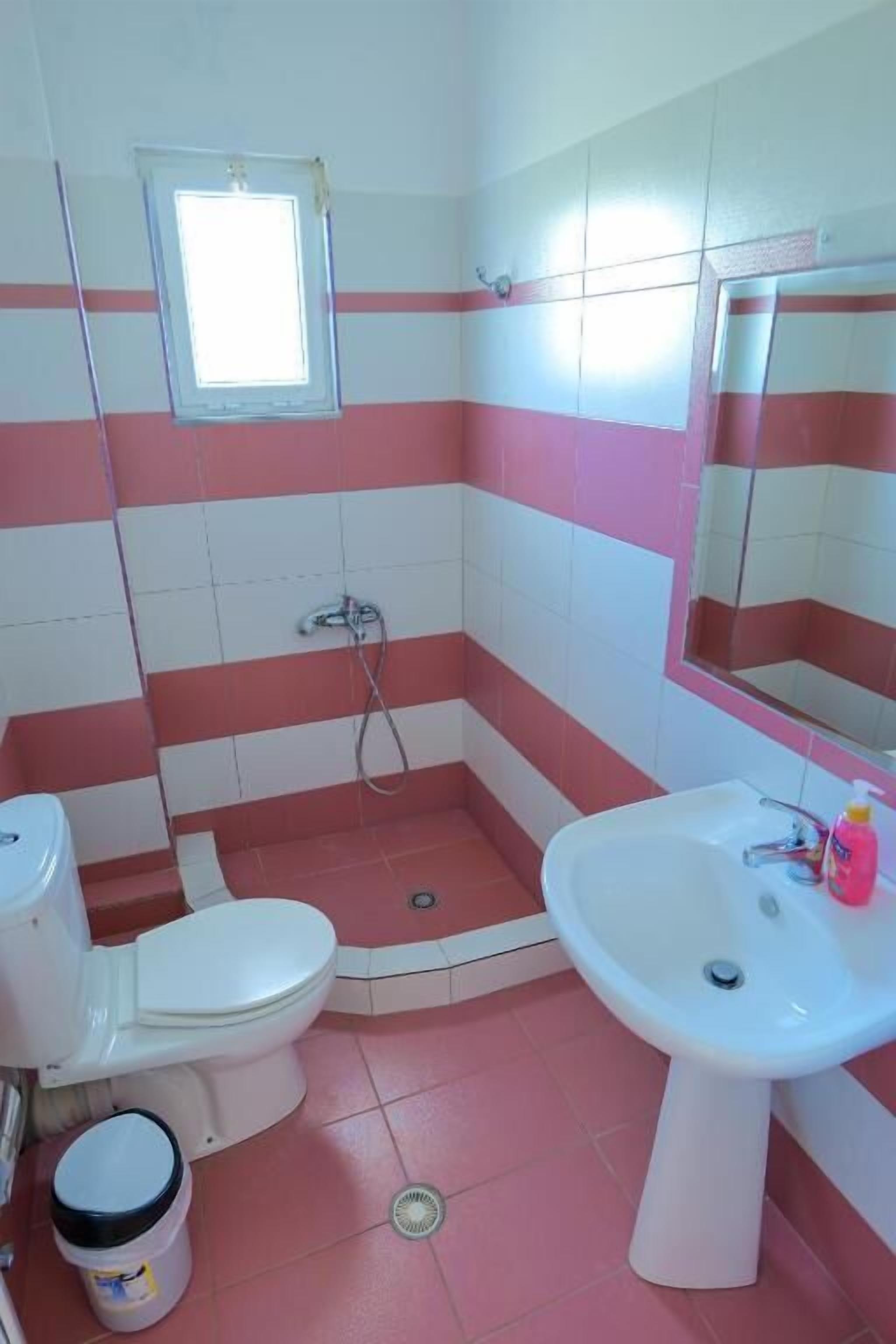 A bathroom with a toilet, sink, and shower.
