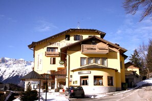 Un edificio amarillo con letrero de restaurante y bar.