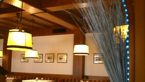 Ein Restaurant mit Tischen und Stühlen, umrahmt von einem Spiegel mit blauen Lichtern.
