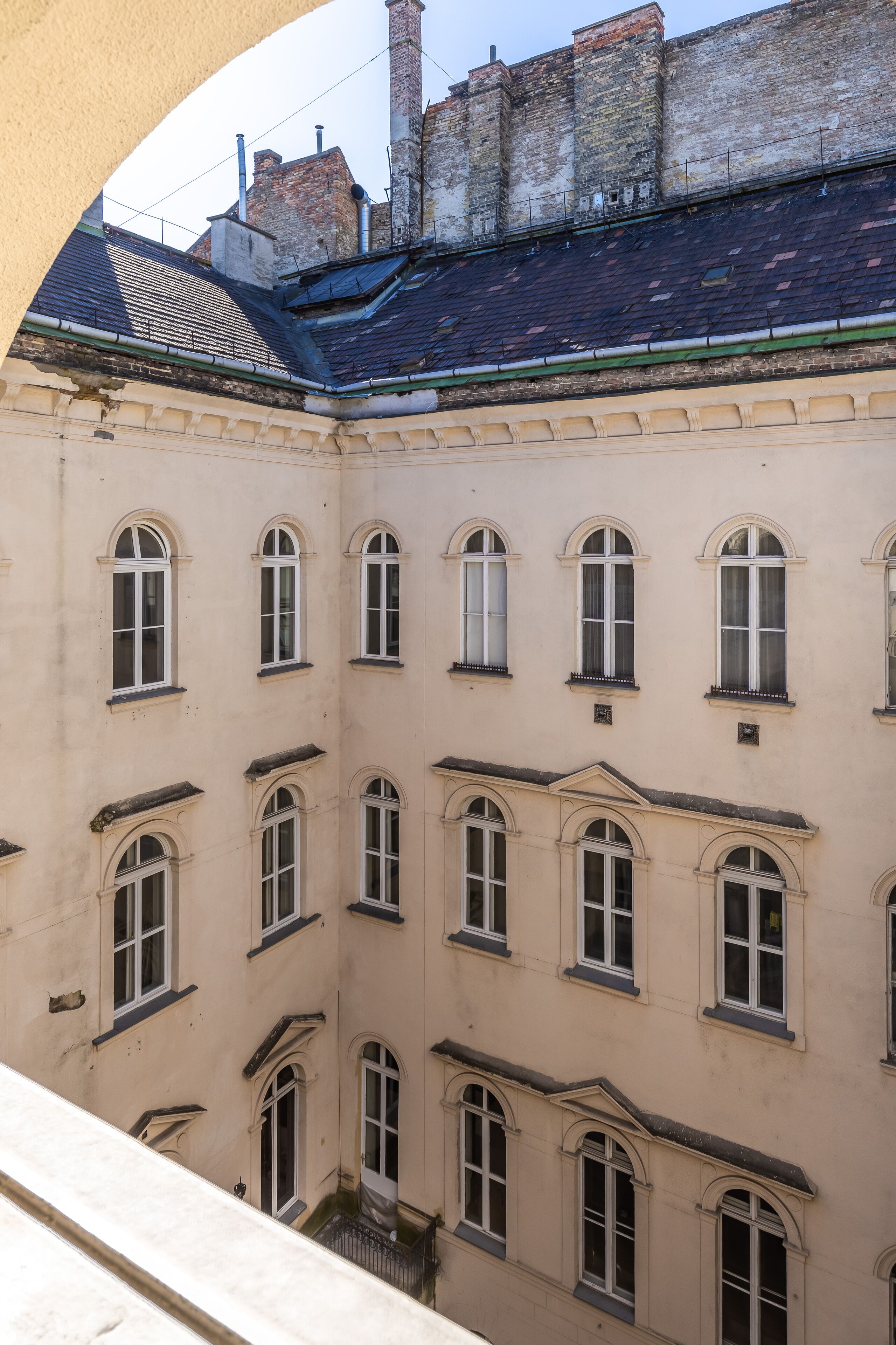 A multi-story building with a symmetrical facade, featuring evenly spaced windows and a central courtyard.