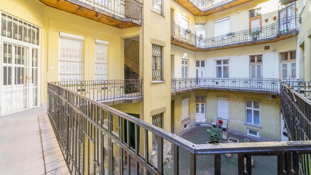 A multi-story residential building with balconies, a courtyard, and a staircase. - Real Apartments Lovag (Budapest)